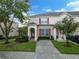 Two story tan townhome with red shutters and a paved driveway at 2364 Silver Palm Dr, Kissimmee, FL 34747