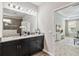 Elegant bathroom with double sinks, granite countertop, and view to living room at 5009 Torchwood Dr, Minneola, FL 34715
