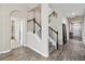 Elegant staircase with dark brown railing and wood-look floors at 5009 Torchwood Dr, Minneola, FL 34715
