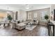 Spacious living room with L-shaped sectional sofa and wood-look floors at 5009 Torchwood Dr, Minneola, FL 34715