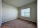Bright bedroom featuring a window with blinds and neutral carpet at 10411 Park Estate Avenue, Orlando, FL 32836