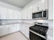 Modern kitchen with stainless steel appliances and white cabinets at 10411 Park Estate Avenue, Orlando, FL 32836