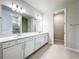 Double vanity bathroom with a large mirror and white cabinets at 10411 Park Estate Avenue, Orlando, FL 32836