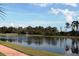 Serene lake view with fountain, lush landscaping, and a walking path at 11542 Brightstowe Way, Orlando, FL 32836