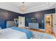 Main bedroom with king bed, navy walls, and views of other rooms at 11542 Brightstowe Way, Orlando, FL 32836