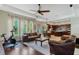 Spacious living room with hardwood floors, leather couches, and a ceiling fan at 11542 Brightstowe Way, Orlando, FL 32836