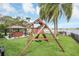 Landscaped backyard with playset and lake view at 621 E Wildmere Ave, Longwood, FL 32750