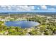Aerial view showcasing a lakefront property with lush greenery and surrounding community at 621 E Wildmere Ave, Longwood, FL 32750
