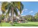Large backyard with a spacious lawn, palm trees, playground, and gazebo at 621 E Wildmere Ave, Longwood, FL 32750