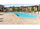 Resort-style pool with lounge chairs and brick patio at 906 Charo Pkwy # 433, Davenport, FL 33897