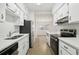 Modern kitchen with white cabinets, stainless steel appliances, and a double sink at 4221 Mizell St, Orlando, FL 32812