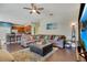 Open living room with kitchen view, L-shaped sofa, hardwood floors, and a large TV at 2053 Nobscot Pl, Apopka, FL 32703