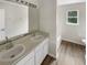 Bathroom with double vanity, white cabinets, and a bathtub at 10472 Eastpark Lake Dr, Orlando, FL 32832