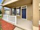 Covered porch with white railing and a blue door at 10472 Eastpark Lake Dr, Orlando, FL 32832