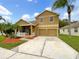 Two-story house with a two-car garage and landscaped yard at 10472 Eastpark Lake Dr, Orlando, FL 32832