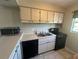Kitchen with white cabinets, black appliances and double sink at 5505 Hernandes Dr # 238, Orlando, FL 32808