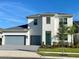 Two-story home with gray garage doors and teal front door at 58 Overleaf Ln, Orlando, FL 32839