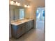 Double vanity bathroom with gray cabinets and quartz countertops at 58 Overleaf Ln, Orlando, FL 32839