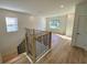 Bright loft area with wood-look floors and a modern railing at 58 Overleaf Ln, Orlando, FL 32839