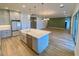 Open concept kitchen with island, stainless steel appliances, and light gray cabinetry at 58 Overleaf Ln, Orlando, FL 32839