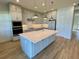 Modern kitchen with stainless steel appliances and a large island with white countertop at 58 Overleaf Ln, Orlando, FL 32839
