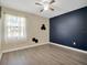 Well-lit bedroom with hardwood floors and a dark accent wall at 500 Teacup Springs Ct, Winter Garden, FL 34787