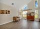 Living room with vaulted ceiling, wood cabinet, and large windows at 500 Teacup Springs Ct, Winter Garden, FL 34787