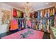 Large walk-in closet with extensive shelving and colorful clothing at 2228 Azalea Pl, Winter Park, FL 32789