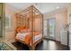 Serene bedroom with bamboo four-poster bed and orange accents at 2228 Azalea Pl, Winter Park, FL 32789