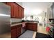 Kitchen boasts wood cabinets, granite countertops, and stainless steel appliances at 1545 Blue Sky Blvd, Haines City, FL 33844