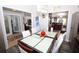 Modern dining room with glass-top table and views into the kitchen and Gathering room at 1545 Blue Sky Blvd, Haines City, FL 33844