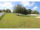 Spacious backyard with grassy area, hammock, and white fence at 1545 Blue Sky Blvd, Haines City, FL 33844