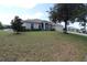 Single-story home on a large lot with mature trees and a landscaped yard at 1545 Blue Sky Blvd, Haines City, FL 33844