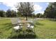 Backyard patio furniture under a large shade tree at 1545 Blue Sky Blvd, Haines City, FL 33844