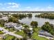 Wide aerial view of a waterfront home on a lake with a city skyline in the distance at 632 Country Club Dr, Winter Park, FL 32789
