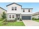 Two-story home with gray and white exterior, landscaping, and a two-car garage at 2363 Lancashire St, Davenport, FL 33896