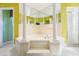 Bathroom with a large corner bathtub and columns at 12616 Crown Point Cir, Clermont, FL 34711