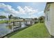 Peaceful waterfront view with a dock and lush green lawn at 121 Jana Cir, Auburndale, FL 33823