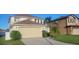 Two-story house with a beige garage and manicured lawn at 115 Canna Dr, Davenport, FL 33897