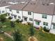 Aerial view of townhomes with brown roofs and white exterior, featuring individual patios and grassy areas at 947 Grandin St, Davenport, FL 33837