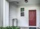 Front door entry with red door and white board and batten at 947 Grandin St, Davenport, FL 33837