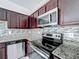 Modern kitchen featuring stainless steel appliances and dark wood cabinets at 947 Grandin St, Davenport, FL 33837