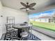 Covered patio with table, chairs, and grill; view of backyard at 653 Persian Dr, Haines City, FL 33844