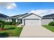 One-story home with gray siding, two car garage, and landscaped yard at 653 Persian Dr, Haines City, FL 33844