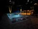 Night view of a refreshing pool with lounge seating at 830 Oakdale St, Windermere, FL 34786