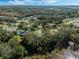 Aerial view of a community with houses, roads, and lush green landscape at 26721 Racquet Cir, Leesburg, FL 34748