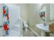 Clean bathroom with shower, toilet and pedestal sink at 7997 Greengard St, Orlando, FL 32827