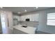 Modern kitchen featuring white cabinets and a large island at 3112 Windswept Way, Wildwood, FL 34785