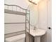 Small bathroom with pedestal sink, toilet and metal shelving at 151 North Orlando Avenue # 142, Winter Park, FL 32789