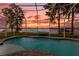 Inviting screened pool with lake view and sunset backdrop at 6320 S Sylvan Lake Dr, Sanford, FL 32771